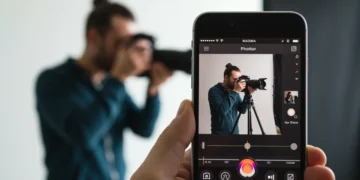 Interface de aplicativo de edição de fotos em um iPhone, com ferramentas avançadas e cores vibrantes, simbolizando a edição profissional em 2025.
