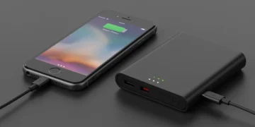 iPhone sendo carregado por uma bateria externa compacta e moderna, simbolizando autonomia estendida.